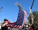 Firefighters get ready to raise tree and the flag.